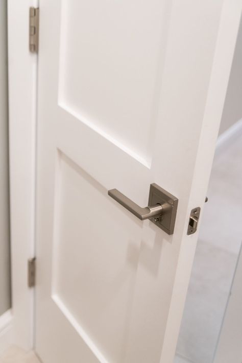 The modern square backplate and handle of this door lever work beautifully with the more traditional shaker panel door. 2 Panel Shaker Door Hardware, Brushed Nickel Door Hardware, Modern Door Trim, Satin Nickel Hardware Door, White Shaker Barn Door, Brushed Nickel Door Knobs, Door Handles Interior Brushed Nickle, Brushed Nickel Door Handles, White Interior Doors