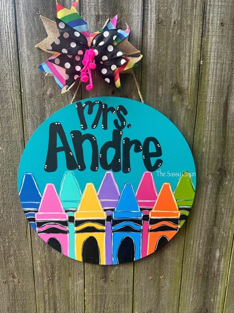 This bright and colorful door hanger can be customized to include any name or school info at the top area.  Please specify what color top area you'd like and  if you have any color preferences for the crayons as well.  Item is hand painted and may vary based on availability and inventory. Painted Door Signs Ideas, Teacher Name Signs Diy, Round Teacher Door Hanger, Crayon Classroom Theme Decor, Teacher Door Hanger Classroom Signs, Back To School Door Hangers, Teacher Diy Gifts, School Door Hangers, Classroom Door Hangers