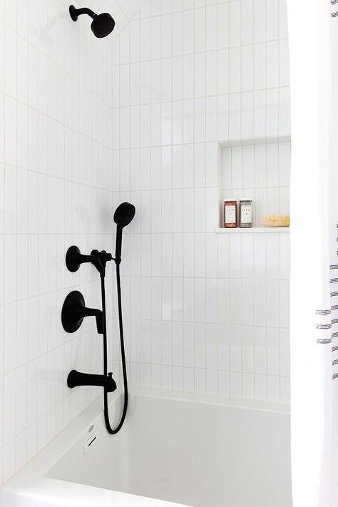 Transitional black and white bathroom boasts a tub and shower combo with a matte black shower kit and white vertical stacked tiles. Stacked Subway Tile Bathroom, Vertical Subway Tile Bathroom, White Subway Tile Shower, White Subway Tile Bathroom, White Tile Shower, Tile Tub Surround, Subway Tile Showers, Subway Tiles Bathroom, Bathtub Tile