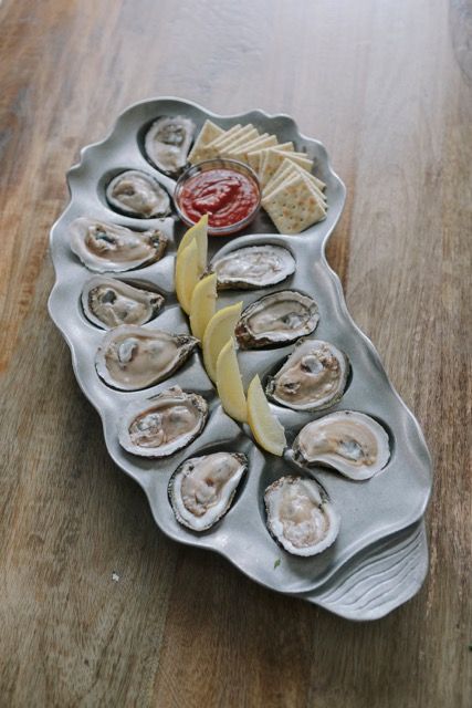 The Oyster Bed plate with a dozen Louisiana oysters on the half shell, lemon wedges, saltine crackers, and dipping sauce Oyster Platter Ceramic, Pottery Oyster Plates, Oyster Presentation, Oyster Tray, Ceramic Oyster Plates, Oyster Platter, Oysters Aesthetic, Oyster Bed, Beautiful Kitchenware