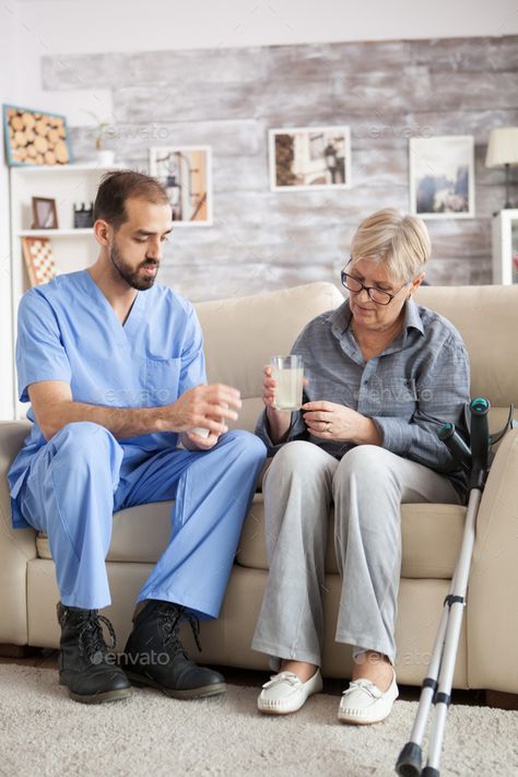 Male nurse sitting on couch with senior woman by DC_Studio. Male nurse sitting on couch with senior woman in nursing home helping her to take the medicine. #AD #couch, #senior, #sitting, #Male Male Nurse Photoshoot, Nursing Home Photography, Director Of Rehab Nursing Homes, Dietary Aide Nursing Home, Home Nursing Services, Home Health Aide Caregiver, Male Nurse, Nursing Care, Home Health Care