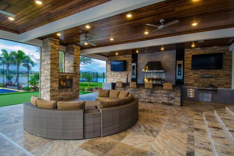 This covered patio features a chic, cozy seating area with a curved sofa and stacked stone fireplace. The patio also boasts a complete outdoor kitchen with a high-end grill and barstool seating. Kitchen Outdoor, Outside Living, Outdoor Kitchen Design, Outdoor Living Areas, Style At Home, Outdoor Rooms, Modern Outdoor, Design Case, Patio Design