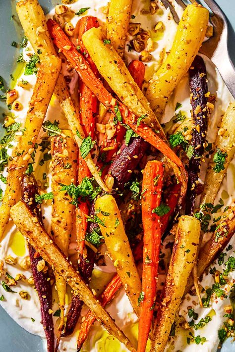 A close up photo of roasted rainbow carrots with with dukkah, mint and a garlicky yogurt sauce on a serving platter. Greek Roasted Carrots, Greek Carrots Recipe, Roasted Carrots Yogurt Sauce, Carrots With Yogurt Sauce, Greek Carrots, Roasted Carrots With Yogurt Sauce, Carrot Recipes Side Dishes, Greek Vegetables, Roasted Winter Vegetables