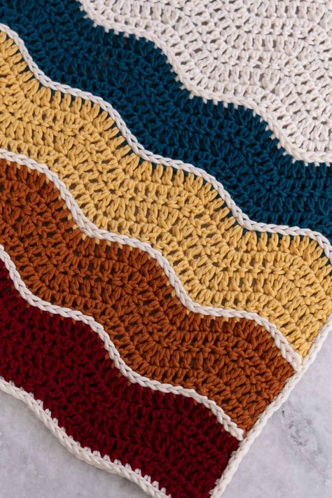 The Wavy Baby Blanket is a free and simple crochet pattern worked in double crochet using the ripple stitch!  The bold color blocking separated by slipped stitch stripes create a striking design that is easily customizable using a color palette of your choice! Long Wave Crochet Stitch, Crochet Blanket One Color Pattern, Wavy Pattern Crochet, Crochet Blanket Patterns 3 Colors, Striped Crochet Blankets, Wavy Crochet Stitch, Wave Stitch Crochet Blanket, Wavy Crochet, Two Color Baby Blanket Crochet Pattern