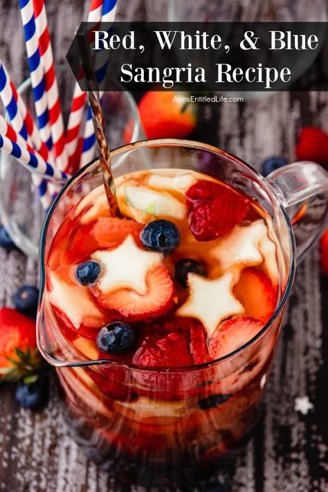 Overhead view of a pitcher of red, white, and blue sangria is a clear pitcher. There are red and white and blue and white straws in a glass to the right. Memorial Day Sangria Recipes, Red And White Sangria Recipes, Memorial Day Sangria, 4th Of July Sangria Recipes, Red White And Two Birthday Food, Red White Blue Cocktails, Patriotic Sangria, Fourth Of July Sangria, 4th Of July Sangria