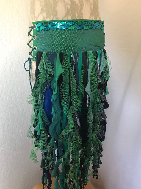 This one of a kind mermaid belt skirt is a unique wearable art piece that is made from reclaimed fabrics and comes with an adjustable pocket.  Wearing this garment will give you a nigh irresistible urge to spin around and shimmy and smile. The Green and Teal Sparkle belt has a base layer of blue and green cross woven taffeta topped with a sparkly green netting and trimmed with a wavey green and teal sequined braid adorning the belt and seaweed-y spirals that accent the sequin colors and dance and flow at your slightest movement while not hampering your motion.  It is a two piece belt that is fastened on the body with lacings on both hips for maximum flexibility in sizing.  It is lined with cotton fabric for comfort. This belt measures about 24 inches in length and is approximately 5.5 inch Sea Skirt, Mermaid Belt, Oregon Outfits, Zombie Mermaid, 2023 Costumes, Formation Ideas, Under The Sea Costumes, Mermaid Inspiration, Sea Costume