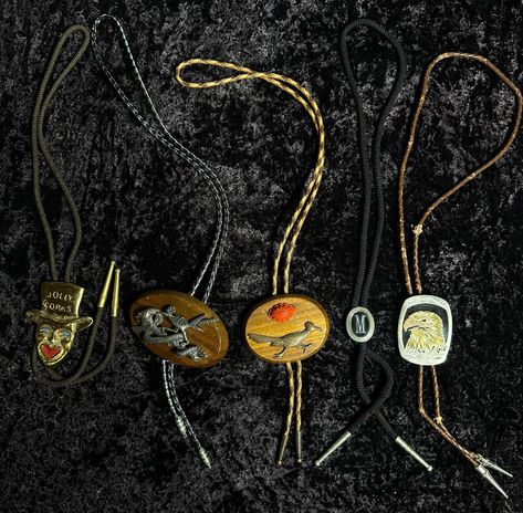 This unique lot of 5 vintage bolo ties offers a diverse collection sure to enhance any wardrobe. Included are two roadrunner-inspired bolo ties, one featuring a striking turquoise accent. Also in the set is a made-in-Germany eagle bolo tie, showcasing exquisite craftsmanship. The lot is rounded out with a 1970s goldstone joker bolo tie and a vintage monogrammed 'M' bolo tie, perfect for adding a touch of retro flair to any outfit. All bolo ties measure approximately 17.5 inches and are in different states of wear and condition. Bolo Tie Outfit, Montana Core, Cowboy Clown, 70s Cowboy, Vintage Bolo Ties With Adjustable Length For Western-themed Events, Handmade Turquoise Vintage Bolo Ties, Adjustable Vintage Turquoise Bolo Tie, Vintage Adjustable Bolo Ties, Vintage Adjustable Turquoise Bolo Tie