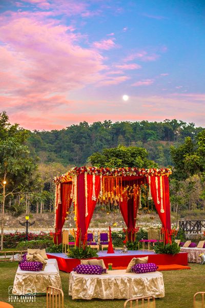 Wedding Decor - Gold and Purple Decor with Red Mandap | WedMeGood | Beautiful Red Mandap Setup in a Open Forest Backdrop #wedmegood #mandap #decor #indianwedding #indiansetup #weddingdecor #indianweddingdecor #decor Indian Wedding Stage, Mandap Design, Wedding Setup, Wedding Hall Decorations, Mandap Decor, Marriage Decoration, Desi Wedding Decor, Beautiful Wedding Decorations, Wedding Backdrop Decorations