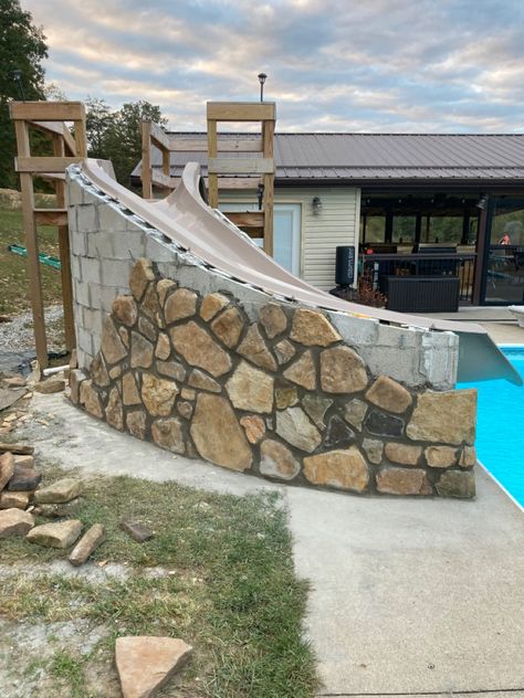 Pool With Rocks Around It, Built In Pool Slide, Above Ground Stone Pool, Pool Slide Ideas, Rock Pool Slide, Rock Water Feature Pool, Pool Playground, Pool Slides Inground, Homemade Pool Slide