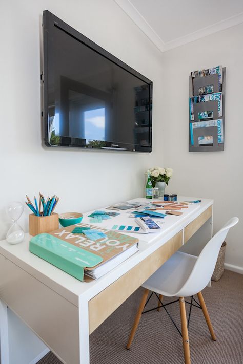 Coastal style office features a flatscreen TV over a white desk with two drawers paired with an Eames Molded Plastic Chair across from a wall mounted magazine holder. Wall Mounted Tv Decor, Chic Workspace, Coastal Style Kitchen, House Of Turquoise, Bedroom Desk, Trendy Bedroom, Bedroom Layouts, Office Spaces, Casual Office