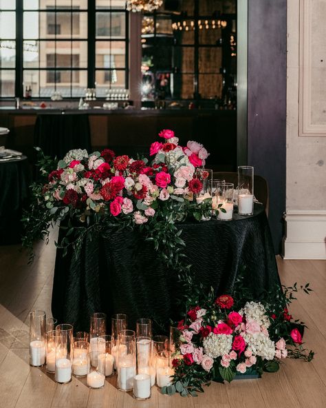 All eyes on the newlyweds and the sweetheart table that is decorated to their liking! 🩷 This HOT pink wedding was the hot topic among guests, wedding teams, and everyone who was WOW-ed by these beautiful pictures captured by @lovestruckpictures photographers! The centerpieces for this gorgeous sweetheart table at @cescaphe ‘s Swith House had a white base with many hot pink elements and touches of red. Sitting atop black tablecloths and situated beside the gentle glow of our candles, we were ... Black Tie Wedding With Color, Red Pink Black And White Wedding, Black Wedding Sweetheart Table, Black Red Pink Wedding, Black Sweetheart Table, Pink Red Black Wedding Theme, White And Black Sweetheart Table, Dark Pink Wedding, Black And Pink Wedding Theme