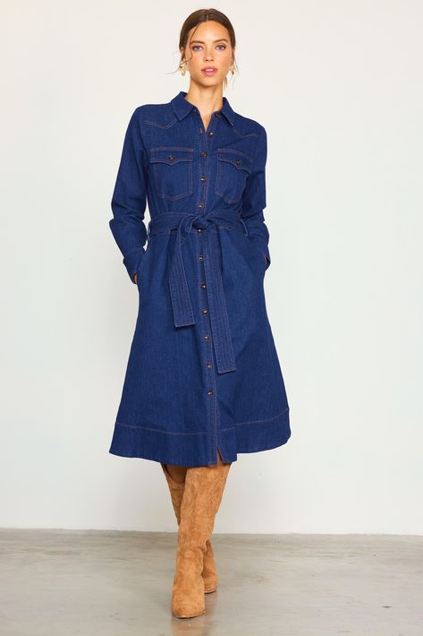 This denim shirt dress comes in a mid-length silhouette with long sleeves and a waist-cinching tie belt. Featuring a clean, dark wash, it showcases Western-inspired flap pockets and yoking accented by contrast topstitching. Button it all the way up to convey a refined look, or leave a few undone to keep things casual. •Pointed collar •Button front placket •Long sleeves with double-button cuffs •Angled yoke •Peaked flap pockets •Optional self-tie belt •Slight Stretch Item Number: 99975 Fabric Con Jean Dress Outfit Fall Boots, How To Style Denim Dress, Adventure Academia, Denim Dress Outfit Winter, Causal Dress Outfits, Denim Shirt Dress Outfit, Denim Dress Outfit Ideas, Denim Dress Winter, Jeans Dress Outfit