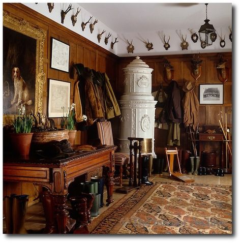 A Swedish ceramic stove stands in a corner of this panelled boot room which is decorated with a display of antlers and hunting trophies Equestrian Interior, Hunter Room, Country Manor House, British Decor, Deer Heads, Robert Kime, Hunting Room, English Interior, Trophy Rooms