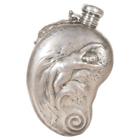 Whiting sterling silver flask. Woman in a wave on front, dolphin near hinge, monogrammed with date on back, and hammered on sides and cap. 6 1/4" PERIOD: Late 19th Century ORIGIN: New York, United States SIZE: 6 1/4", 8.15 troy ounces Whiting Manufacturing Co traces its origin to the firm Tifft & Whiting formed in 1840 by Albert C. Tifft and William Dean Whiting. After the retirement of Tifft the firm changed to Whiting & Gooding (& Co) in 1853, Whiting Fessenden & Cowan (1858), Tifft Whiting & Old Trinkets, Old Accessories, Attleboro Massachusetts, Silver Flask, Silver Flatware, Cow Boy, Jewelry Inspo, Objects Design, Rhode Island