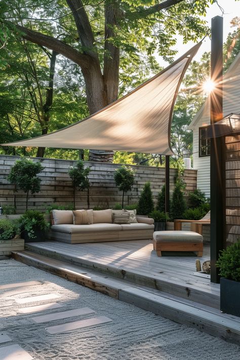 Unwind in a serene patio retreat with plush seating and soothing shade. A beige sail casts cool shadows, while lush greenery and sunlight create a warm, inviting glow. Explore how to craft your own outdoor oasis. Click for more garden inspiration! Minimalist Pergola, Sunshade Ideas, Patio Retreat, Terraced Landscaping, Pergola Design, Patio Shade, Balanced Design, Pergola Designs, Outdoor Retreat