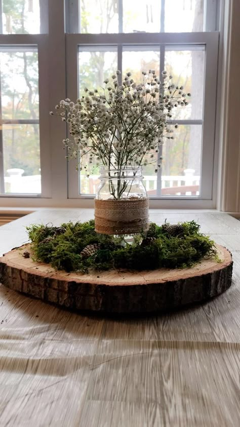 Centerpieces were made from a tree cut from the Mom to be’s yard, Moss was added on top to create a forest feel and pine cones were spray painted with gold glitter to add a pop of sparkle. The mason jars were reused from Mom and Dad to be’s wedding and babies breathe added a perfectly simple final touch to the tables. Table clothes were a white bitch print, actually being sold as Thanksgiving decor, but they worked perfectly with our theme! Tree Cut Centerpiece, Centerpieces Woodland Theme, Woodsy Baby Shower Table Centerpieces, Woodland Table Centerpieces, Forest Centerpiece Ideas, Woodland Baby Shower Theme Centerpieces, Woodland Centerpiece Ideas, Moss Table Decor, Woodsy Baby Shower Ideas