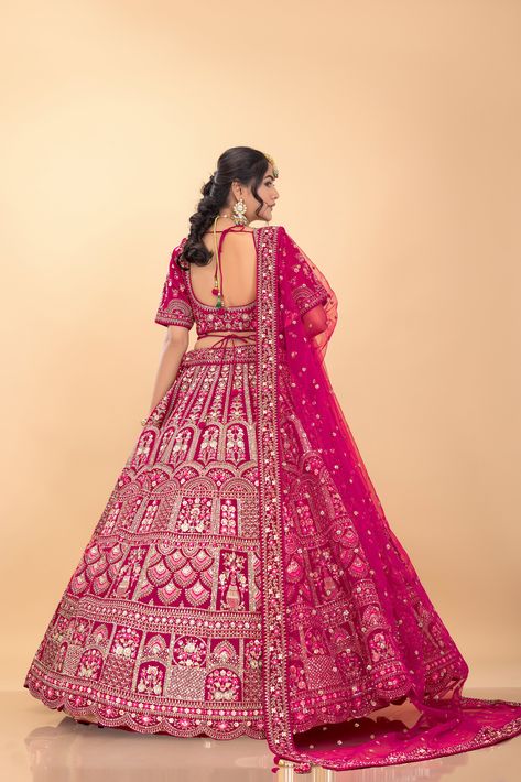 Embark on your fairytale wedding in this Rani Pink Velvet Bridal Designer Lehenga Choli from Palkhi Fashion. This exquisite ensemble features a luxurious velvet lehenga adorned with shimmering petite stones, kundan, delicate threadwork, elegant zari embroidery, handwork, and sequin work. The attractive designs and rich texture create a look of unparalleled sophistication, fit for a queen. The matching blouse is embellished with intricate handwork and features a beautifully designed back. Complet Rani Pink Bridal Lehenga, Palkhi Fashion, Pink Bridal Lehenga, Velvet Lehenga, Rani Pink, Zari Embroidery, Embroidered Belt, Bridal Lehenga Choli, Pink Bridal