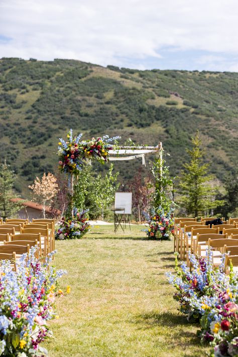 Blue delphinium, green hydrangea, fuchsia snapdragons, yellow freesia, coral dahlia, fuchsia garden rose, bells of ireland, coral peony, pink veronica ceremony aspen birch chuppah, ceremony aisle entry floral hedge Wild Flower Aisle, Wildflower Chuppah, Wildflower Wedding Ceremony, Floral Hedge, Colorful Wildflower Wedding, Pink Veronica, Birch Chuppah, Coral Dahlia, Yellow Freesia