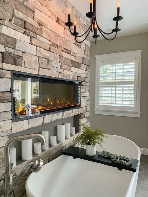 Luxury master bathroom with a built in fireplace and large white bathtub. Kylie Interiors, Master Bathtub Decor, Bathroom Stone Wall, Bathroom Stone, Fireplaces Layout, Large Bathtub, Bathroom Large, Barn Homes Floor Plans, Copper House