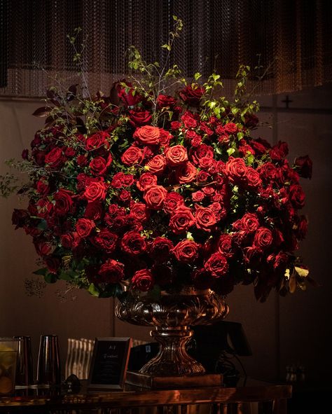 A rich palette of bold reds, lush roses, and glimmering candlelight created a dramatic and sophisticated atmosphere, celebrating love in its most vibrant form at the Londoner. The venue’s contemporary elegance set the stage for an unforgettable evening, with @craigdavid’s performance adding additional touches of romance into the magic of the night ❤️🌹 #romanticweddingtheme #luxuryweddingplanner #timelessromance #bespokeweddingdesign  #luxuryeventdecor #weddinginspo2025 Massive Flower Bouquet, Dark Red Floral Arrangements, Red Floral Arrangements, Red Rose Bouquet Wedding, Luxury Event Decor, Dark Lighting, Romantic Theme Wedding, Rose Tree, Red And White Weddings