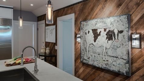 Reclaimed barn wood placed on the diagonal adds rustic warmth on the feature wall in this cozy kitchen. Cow artwork provides a cheeky nod to the wood's origin, while modern pendant lights and limestone countertops keep the space from feeling overly rustic. Rustic Modern Kitchen Ideas, Flooring On Walls, Timber Feature Wall, Fancy Farmhouse, Wall Paneling Ideas, Boho Loft, Barn Wood Ideas, Paneling Ideas, Barn Wood Decor