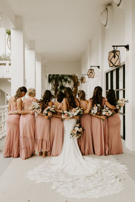 Bridesmaids facing away and holding their flowers behind them with their arms around each other. Bridesmaids With Bride, Uneven Bridesmaids Pictures, 3 Bridesmaid Photoshoot Ideas, Photoshoot Bridesmaids, Bride And Bridesmaid Pictures Ideas, 8 Bridesmaids Pictures, 7 Bridesmaids Pictures, Bridesmaid Photoshoot Ideas Group Shots, Bridesmaid Pics