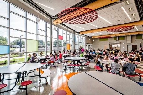 Bright, fun, and colorful. Cafetorium transforms from a lunchroom into a performance space, featuring acoustical baffles, a sound system, and performance lighting. Exposed building systems encourage systems thinking. | Cafeteria + Auditorium | Steger Intermediate Center | DLA Architects Orphanage Building, School Interiors, School Lunchroom, Elementary School Architecture, Cafeteria Design, School Cafe, School Designs, American High School, Systems Thinking