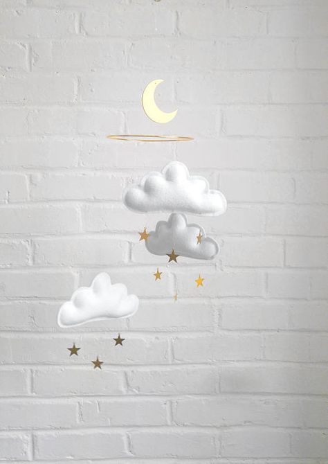 Wonderful mobile with 3 gorgeous grey puffy fluffy felt clouds on a 6 gold ring as the pictures 1 to 6. Description: .white rainclouds with gold mini stars. Each rainclouds measures 15cmx 8cm Lenght : 66 cm / 26 A mini star measure: 2 cm 100% Felt 3 inch wood moon painted in gold White And Gold Nursery, Cloud Mobile Nursery, Gold Nursery Decor, Nursery Trends, Neutral Baby Gifts, Minimalist Nursery, Gold Nursery, Cloud Mobile, Star Mobile