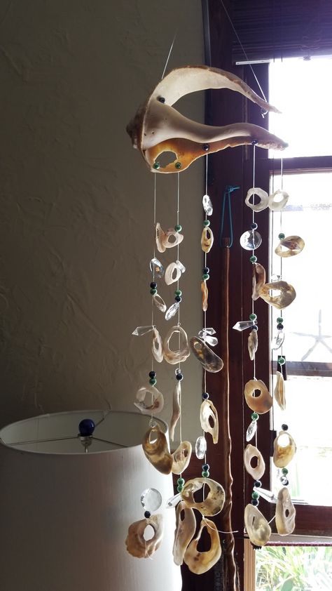 Handcrafted suncatcher or mobile.  Made with authentic shells from Assateague Island off the eastern coast of Maryland, or The Outer Banks N.C. The shells are artfully strung together with crystals and crystal beads, sometimes pearls hanging from a piece of driftwood found on the beaches right here in my community on the Chesapeake Bay, Md . Macrame With Shells Wall Hanging, Shells Diy Decoration, Shell Windchimes Diy, Mobile Hanging Ideas, Driftwood Crystals, Things To Do With Shells, Shell Suncatcher, Stone Mobile, Hanging Shells