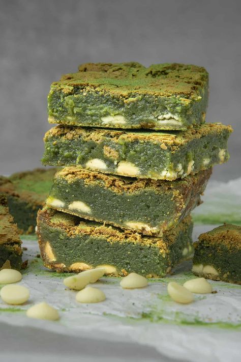 Four Matcha brownies on top of each others surrounded with white chocolate decoration Japanese Jiggly Cheesecake Recipe, Hokkaido Baked Cheese Tart, Spatula Desserts, Matcha Brownies, Pistachio Baklava, Green Tea Matcha, Raspberry Brownies, Matcha Dessert, Matcha Cookies