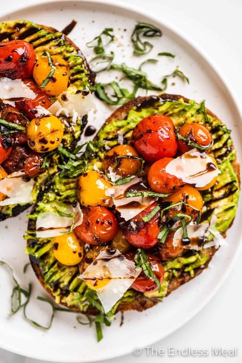 Enjoy this flavorful avocado tomato toast as a light meal, or slice it up and serve it as an appetizer. Grilled sourdough is topped with ripe avocado, sautéed cherry tomatoes, parmesan, and basil, then drizzled with balsamic glaze. It's easy to make and ready in just 10 minutes! #theendlessmeal #avocadotoast #toast #avocados Avocado Toast Balsamic Glaze, Balsamic Avocado Toast, Avocado Toast With Balsamic Glaze, Avocado Toast With Egg And Tomato, Avocado Toast With Tomatoes, Avocado Tomato Toast, Vegan Avocado Toast, Gourmet Toast, Tomato Toast