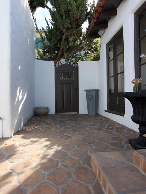 This Spanish-style kitchen courtyard forms an arresting study in contrasts. Terra-cotta-toned concrete pavers and red barrel roof tiles appear richer against pristine white walls, which in turn look luminous against the dark door and window casings. Mediterranean Courtyard, Backyard Goals, Spanish Style Kitchen, Spanish Bungalow, Patio Tiles, Mediterranean Home Decor, Spanish Style Home, Casas Coloniales, Spanish Style Homes