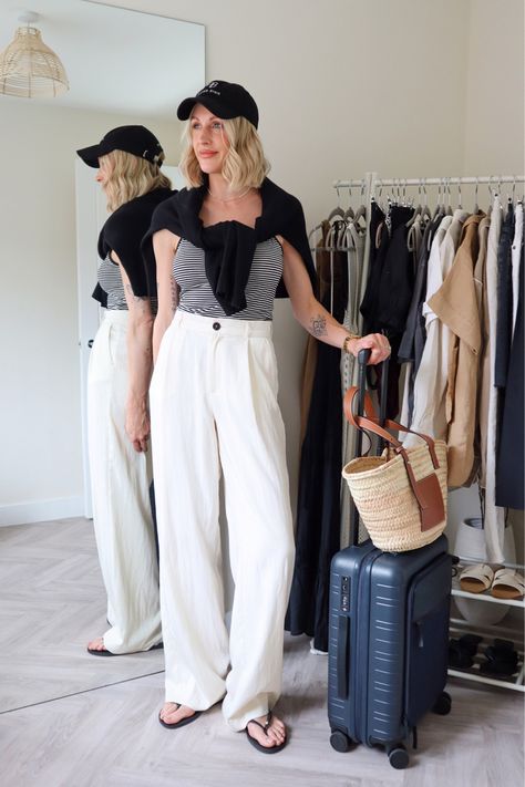 Airport style - travel outfit - everyday outfit - casual style - wide leg trousers - striped top - black cardigan - chic look - black baseball cap - loewe basket bag - uk fashion influencer Follow my shop @charlottebuttrick on the @shop.LTK app to shop this post and get my exclusive app-only content! #liketkit #LTKtravel #LTKitbag #LTKeurope @shop.ltk https://liketk.it/3LXds Wide Leg Trousers Airport Outfit, Linen Pants Airport Outfit, Wide Leg Pants Airport Outfit, Wide Leg Trousers Outfit Casual, Air Travel Outfits, Trendy Airport Outfits, Ootd Airport, Outfit Ideas For Travel, Leg Trousers Outfit