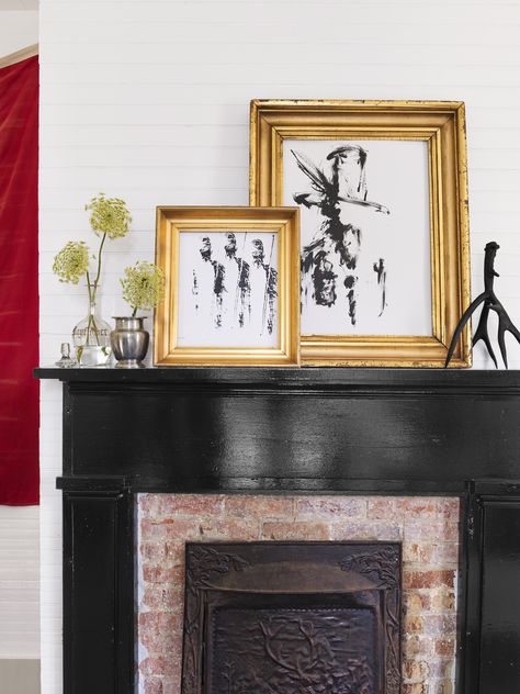 This fireplace is painted black, providing a stark contrast with the home's white walls. Simple art is displayed on the mantel. Brick Fireplace Decor, Black Mantle, Holly Williams, Red Brick Fireplaces, Painted Brick Fireplaces, Black Fireplace, Fireplace Art, Farmhouse Renovation, Farmhouse Fireplace