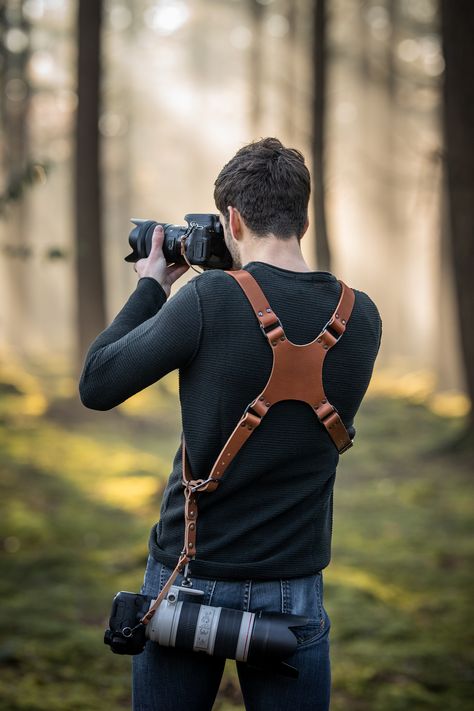 Handmade leather camera harness, photographer with sunset using a dual camera holster Leather handmade Camera Strap, Camera Harness, personalized dual camera holster, custom leather camera harness, Accessory for professional photography, Camera neck and shoulder straps, Quality leather harnesses and straps for photographers, Leather camera neck and shoulder straps, photography accessories, personalized with your logo or personal design Leather Camera Harness, Camera Holster, Professional Photography Camera, Leathercraft Ideas, Camera Harness, Diy Leather Projects, Photography Accessories, Leather Harness, Camera Strap