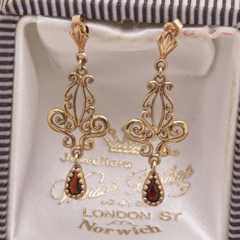 The gemstones in the jewellery are all natural stones. We do not sell jewellery containing manmade, synthetic or laboratory grown stones. This stunning pair of Victorian design ornate vintage drop earrings has been beautifully crafted in 9 carat yellow gold, each earring having a teardrop/pear cut garnet bead set hanging from the scrolled design. A perfect anniversary or birthday gift. Hallmark - The earrings do not have any hallmarks but have been tested and present as 9ct gold. Weight - 1.6g ( Designer Earrings Gold, Gold Earrings Vintage, Victorian Gold Jewelry, Vintage Earrings Victorian, Victorian Gold Earrings, October Jewelry, Victorian Drop Earrings, Ornate Jewelry, Victorian Jewellery