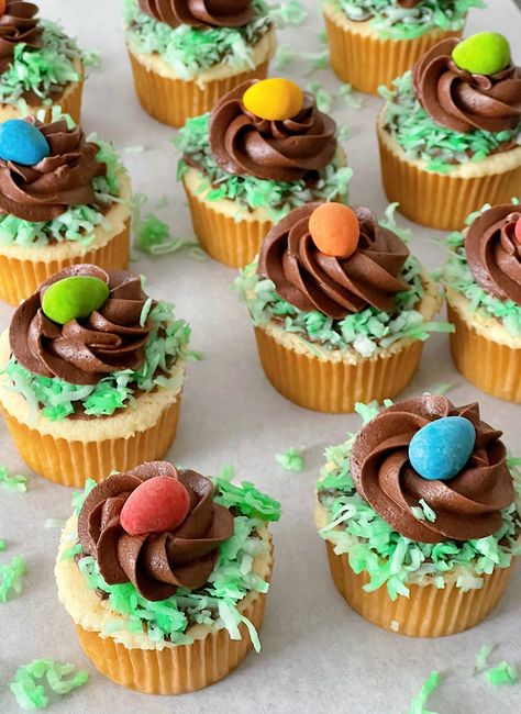 Get ready to hop into Easter with these Easy Easter Egg Cupcakes! These adorable treats feature moist vanilla cupcakes topped with rich chocolate frosting, green-tinted coconut for grass, and a sweet candy egg for a festive touch. Perfect for adding a pop of springtime fun to your Easter brunch dessert table! Brunch Dessert Table, Easter Brunch Dessert, Nest Cupcakes, Moist Vanilla Cupcakes, Brunch Dessert, Egg Cupcakes, Easter Nests, Candy Egg, Easter Food