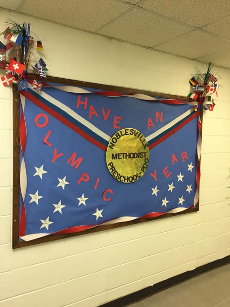 Bulletin board for our preschool celebrating the Olympics this year. All the mini stars contain our staff names. Gold medal was made with foil covered with yellow clear wrap. We are super excited to support the red, white, blue and our preschool this Olympic year! Go USA! Going For Gold Bulletin Board, Champion Bulletin Board Ideas, Go For The Gold Bulletin Board, Olympic Decorations Classroom, Olympic Theme Bulletin Board Ideas, Olympic Bulletin Boards For School, Olympic Bulletin Board Ideas, Olympic Bulletin Board, Summer Olympics Crafts