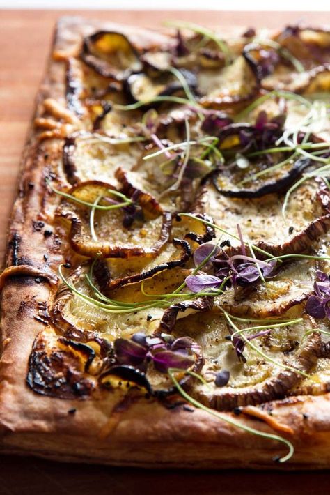 Eggplant Tart With Goat Cheese, Honey, and Nigella Recipe | Store-bought puff pastry gets all gussied up (or should we say tarted up?) with the help of creamy goat cheese, nutty Gouda, aromatic nigella seeds, and late-summer eggplant. This tart is finished with a drizzle of honey to contrast the salty bite of the cheese and the crisp, buttery pastry. Baking the puff pastry twice ensures it's fully cooked through, emphasizing all the pastry's brittle and flaky layers. Fried Eggplant Recipes, Goat Cheese Honey, Small Eggplant, Puff Pastry Tart, Eggplant Dishes, Cheese Tarts, Frozen Puff Pastry, Eggplant Recipes, Serious Eats