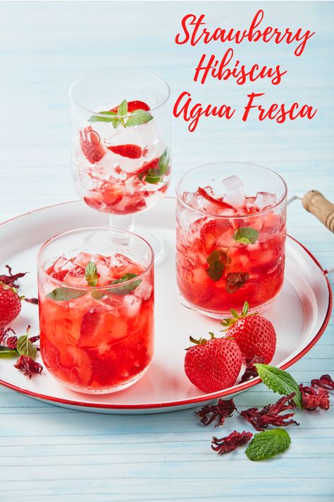 Quench your thirst with this fresh, strawberry hibiscus agua fresca. Aguas frescas or “fresh waters” are non-alcoholic beverages made of fresh fruits. Strawberries and hibiscus are the perfect combination for this refreshing recipe. #californiastrawberries #aguafresca #mocktail #beverage #strawberry #freshwater #infusedwater #nonalcoholicdrinks Auga Frescas, Hibiscus Agua Fresca, Hibiscus Refresher, Fruit Waters, Roselle Hibiscus, Hibiscus Water, Strawberry Hibiscus, Agua Fresca Recipe, Virgin Drinks