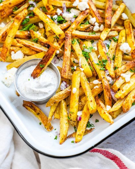 These crispy Greek fries are the ultimate side dish! They're showered with Mediterranean-style toppings: feta cheese, onion and herbs. #greekfries #greek #fries #frenchfries #easy #homemade #fries Greek Cucumber Sauce, Greek Side Dishes, Greek Fries, Seasoned Fries, A Couple Cooks, Homemade Fries, French Fries Recipe, Greek Seasoning, Feta Recipes