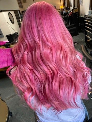 The back of a woman's head who has long (mid-back) bright pink hair.  It is curled and a stylist is holding a stand. Pink Hair Bubblegum, Bubblegum Hair Color, Pink Hair On Pale Skin, Pink Mermaid Hair, Barbiecore Hair, Pink Magenta Hair, Raspberry Pink Hair, All Pink Hair, Pink Hair Hairstyles