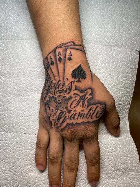 Stencil Hand Tattoo, Hand Tattoos Men Black, Life’s A Gamble Hand Tattoo, Money Tattoo Men, Boy Hand Tattoos, Hand Tattoo Designs Men Ideas, Guy Hand Tattoos, Hood Hand Tattoos, Black Men Hand Tattoos