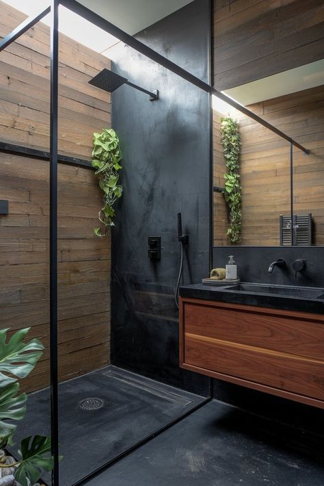 Bold meets beautiful in this contemporary bathroom design featuring dark teak elements harmoniously blended with sleek black concrete surfaces. #ContemporaryDesign #TeakWood #BathroomDecor Black Aesthetic Bathroom Ideas, Black Wood Tile Bathroom, Bathroom Dark Design, Dark Polished Concrete Floor, Dark Contemporary Bathroom, Concrete Wood Bathroom, Dark Bathroom Tile Ideas, Dark Colored Bathrooms, Dark Earthy Bathroom