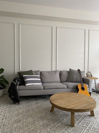 A modern living room accent wall with picture frame molding Apartment Wall Molding, Accent Walls With Wood, Walls With Wood Trim, Molding Accent Wall, Wainscoting Accent Wall, Frame Wainscoting, Mumbai House, Wall Molding Living Room, Living Room Accent Wall