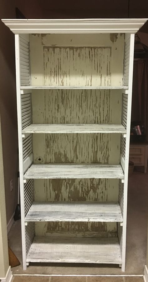 This is a bookshelf made from an old pocket door, shutter doors and pallet wood for the shelves. Old Door Bookshelf, Shelves Made From Old Doors, Shutter Bookshelf, Shutter Shelves, Shutters Repurposed Decor, Door Bookshelf, Shutter Shelf, Old Window Shutters, Rustic Style Furniture