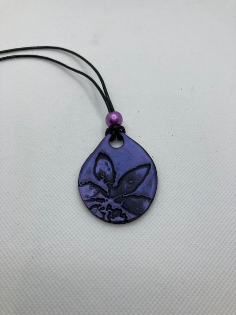 Hand Stamped Black Polymer Clay with Purple Mica Powder to shine. Necklace is 16 inches long. Pendant is 2 inches long. This necklace is fully hand made and hand finished so slight variations in color/finish should be expected. Mica Powder color will shine differently in different light. Black Polymer Clay, Flower Clay, Polymer Clay Jewelry Tutorials, Keramik Design, Ceramic Necklace, Polymer Clay Necklace, Clay Necklace, Ceramic Pendant, Funky Jewelry