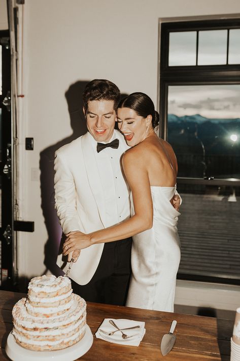 A groom in a white suit with black bowtie, and a bride with a sleek bun and cocktail dress cut a milk bar cake at their wedding. Reception Dress Change, Milk Bar Cake, Cream Color Palette, Wedding Photo List, Bar Cake, Wedding Shot List, Hunter Wedding, Anniversary Shoot, Vendor List