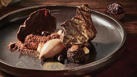 Inspired+by+Rondnoir,+this+deconstructed+dessert+is+captured+within+golden+wrapping+(made+of+tempered+chocolate+dusted+in+gold).+With+chocolate+gelato,+cremeux,+smoked+hazelnut,+chocolate+tuile,+soil,+wafer+crisps,+and+Rondnoir,+this+is+the+perfect+recipe+for+serious+baking+buffs. Koi Dessert Bar, Chocolate Soil, Hazelnut Dessert, Tempered Chocolate, Christmas Cookies Packaging, Fine Dining Desserts, Chocolate Torte, Dessert Chocolate, Gourmet Desserts