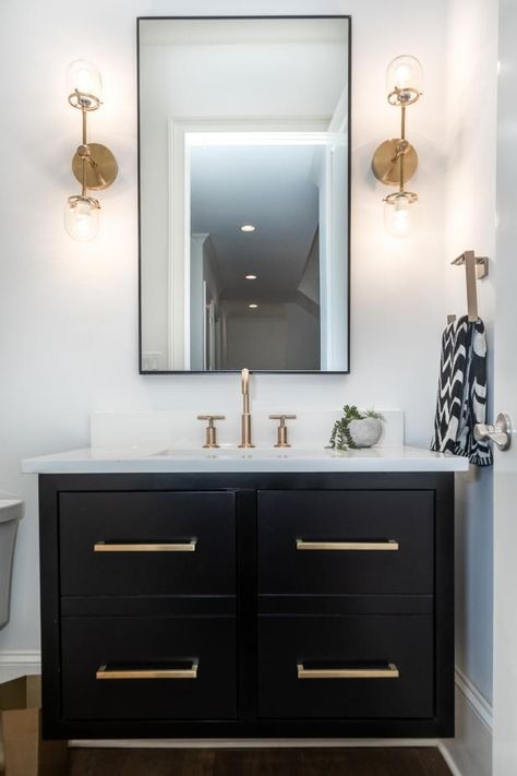 HGTV features a white powder room with a black vanity with gold-toned hardware, a black-framed mirror and gold-toned double sconces. Gold Bad, Black And Gold Bathroom, Bathroom Vanity Designs, Bad Inspiration, Black Vanity, Vanity Design, Gold Bathroom, Double Bathroom Vanity, Bathroom Remodel Master